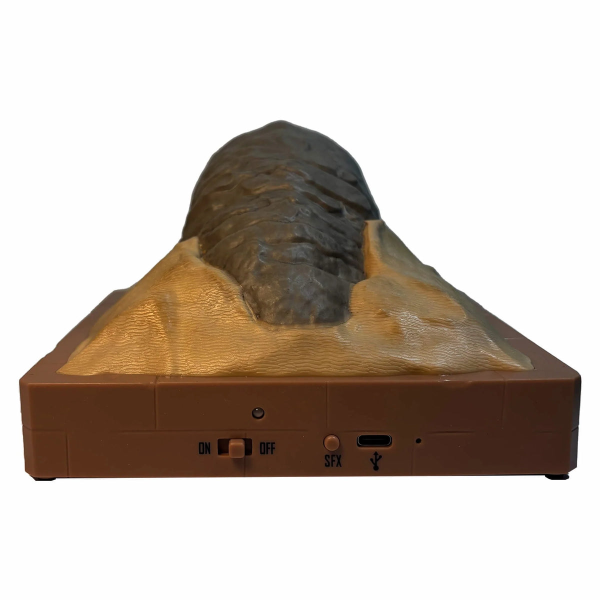 Close-up of the textured sand and rock formations at the base of the sandworm figurine