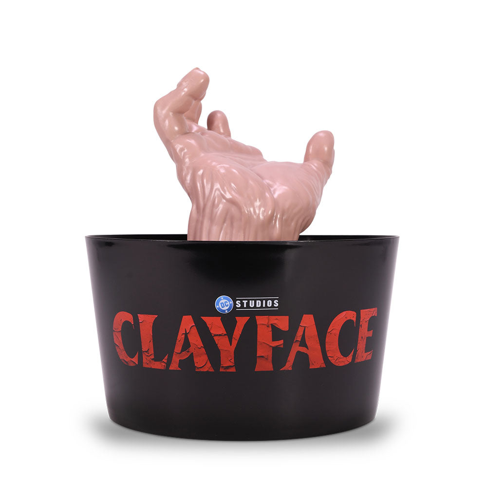 Front view of the Clayface figural hand popcorn bucket molded in a menacing mud-textured shape