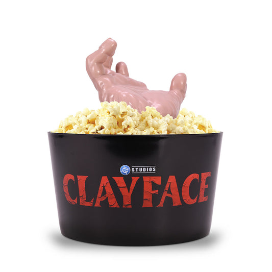 Angled side view of the 80 oz Clayface popcorn container showing its sculptural hand design