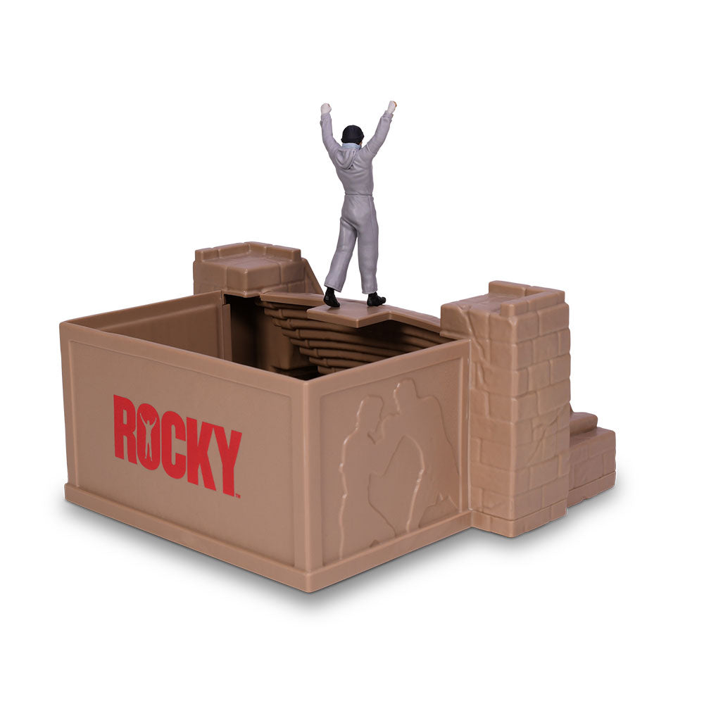 Angle view of the red plastic Rocky popcorn bucket showing the textured staircase artwork