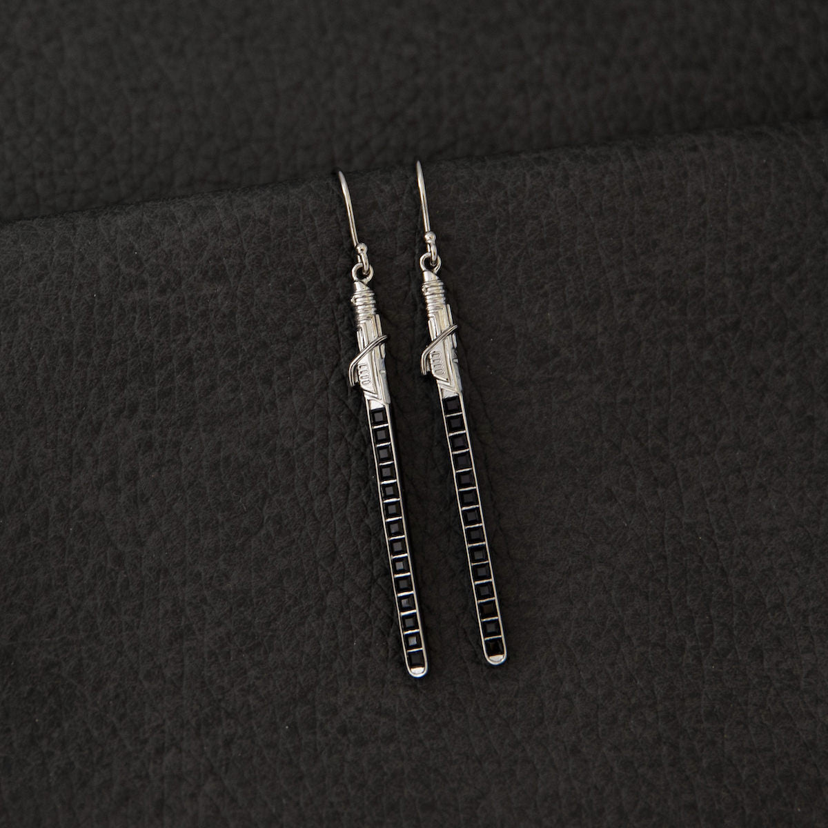Handcrafted sterling silver Star Wars Darksaber earrings showing the French wire hooks.