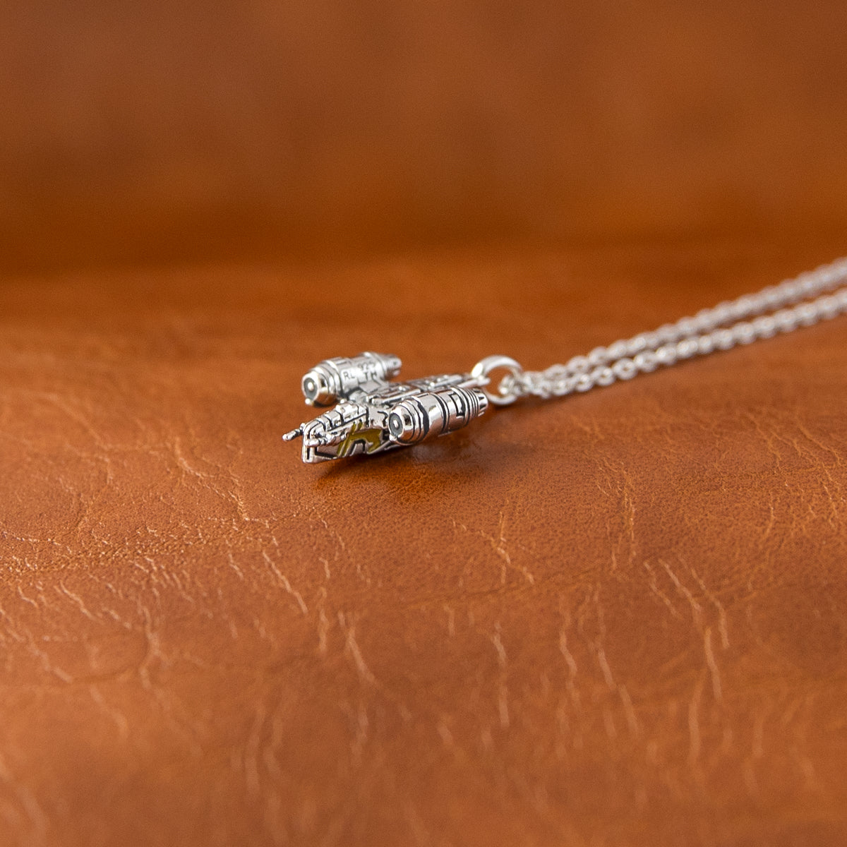 Antiqued sterling silver Razor Crest pendant on white background